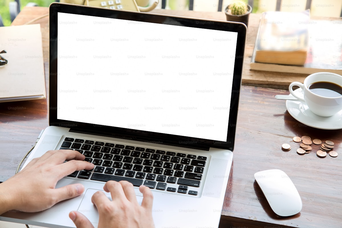 Geschäftsmann bearbeitet Rechnung mit Laptop und Dokumenten am Schreibtisch